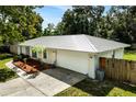 Charming ranch house with a metal roof, landscaping, and a two-car garage at 1025 North St, Longwood, FL 32750