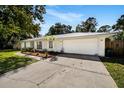 Charming ranch house with a metal roof, landscaping, and a two-car garage at 1025 North St, Longwood, FL 32750