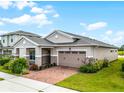 Tan house with two-car garage and landscaped yard at 2717 Greenlands St, St Cloud, FL 34772