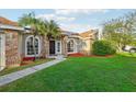 Brick house with palm trees, walkway, and a well-maintained lawn at 1546 Thornhill Cir, Oviedo, FL 32765