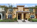 Tan two-story house with a covered entryway and landscaping at 8947 Bismarck Palm Rd, Kissimmee, FL 34747