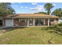 Brick ranch home with a covered porch and well-maintained lawn at 1421 Avenue G Ne, Winter Haven, FL 33881