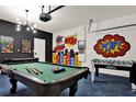 Fun game room with pool table, foosball and comic theme at 453 Ocean Course Ave, Champions Gate, FL 33896