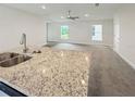 Granite countertop kitchen island with a double sink overlooking the living room at 4197 Sagefield Dr, Harmony, FL 34773