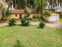 Ranch style home with circular driveway and mature landscaping at 16 Cypress Dr, Eustis, FL 32726