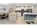 Modern kitchen boasts stainless steel appliances and an island with seating at 4751 Clock Tower Dr # 105, Kissimmee, FL 34746