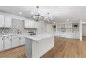 Modern kitchen with white cabinets, marble island, and geometric backsplash at 4720 Sw 22Nd Pl, Ocala, FL 34474