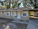 Tan single story house with white trim, covered carport, and small front yard at 5146 Liming Ave, Orlando, FL 32808