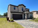 Two-story house with stone accents and a brown garage door at 226 Macaulays Cv, Haines City, FL 33844