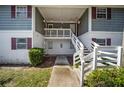 Two-story building with gray siding, a balcony, and a white staircase leading to the entrance at 8202 Fairways Cir # B202, Ocala, FL 34472