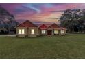 House exterior at dusk, showcasing the red roof and landscaping at 14742 Sw 4Th Ave, Ocala, FL 34473