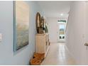 Light and airy hallway with tile floors and coastal decor at 2924 Waterlily Way, Poinciana, FL 34759