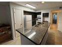 Kitchen with granite countertops and dark cabinets at 470 S Pin Oak Pl # 204, Longwood, FL 32779
