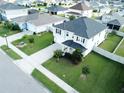 Two-story house with gray siding, black roof, and a well-manicured lawn at 2346 Upland Ln, Apopka, FL 32712