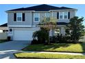 Two-story house with gray siding, white garage door, and landscaping at 2346 Upland Ln, Apopka, FL 32712