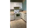 Bright kitchen with white cabinets and tiled floors at 7622 Forest City Rd # E, Orlando, FL 32810