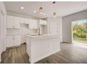 Modern kitchen with white cabinets and island at 1308 Hillsborough Ct, Kissimmee, FL 34759