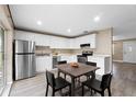 Modern kitchen with white cabinets, stainless steel appliances, and a dining area at 106 Oregon Ave, Saint Cloud, FL 34769