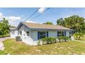 Side view of single story home, white with blue trim at 168 E Sunset St, Groveland, FL 34736