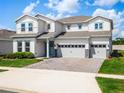 Two-story house with gray siding, three car garage, and landscaped yard at 3198 Sailing Pier Ave, Winter Garden, FL 34787