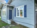 Gray house exterior with blue shutters and a blue door at 1628 S Grove St, Eustis, FL 32726