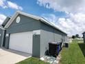 Gray house with white garage door, and green lawn at 714 Hacienda Cir, Kissimmee, FL 34741