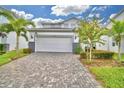 Two story house with white garage door and paver driveway at 1687 Kona Ln, Davenport, FL 33897