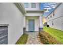 Light blue front door entry with gray stone and landscaping at 1687 Kona Ln, Davenport, FL 33897