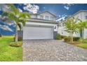 Two-story house with white garage door and paver driveway at 1687 Kona Ln, Davenport, FL 33897