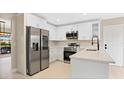 Modern kitchen with white cabinets and stainless steel appliances at 7972 Snowberry Cir, Orlando, FL 32819