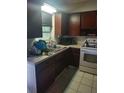 Galley kitchen with dark wood cabinets, granite countertops, and white appliances at 108 5Th Jpv St, Winter Haven, FL 33880