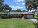 Brick ranch home with a two-car garage and a large yard at 704 Tangelo Ct, Winter Garden, FL 34787