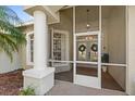 Enclosed front porch with double doors and decorative wreaths at 122 Loma Del Sol Dr, Davenport, FL 33896