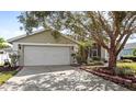 Two-car garage with a landscaped front yard and a paved driveway at 122 Loma Del Sol Dr, Davenport, FL 33896