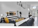 Bright living room with high ceilings and L-shaped sofa at 145 Cork Way, Davenport, FL 33897