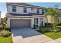 Two-story house with attached garage, landscaping, and a palm tree at 547 Marcello Blvd, Kissimmee, FL 34746