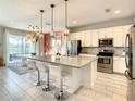 Modern kitchen with stainless steel appliances, white cabinets, and a large island at 547 Marcello Blvd, Kissimmee, FL 34746