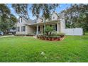 Two-story house with neutral siding, welcoming porch and lush landscaping at 70 Millholland St, Oakland, FL 34760