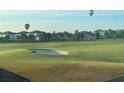 View of a golf course with hot air balloons in the distance at 8920 Dove Valley Way, Davenport, FL 33896