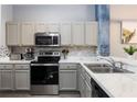 Modern kitchen featuring stainless steel appliances and white cabinets at 3052 Secret Lake Dr, Kissimmee, FL 34747