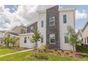 Two-story modern home with gray and white exterior and landscaping at 9102 Sommerset Hills Dr, Davenport, FL 33896
