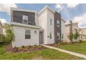 Two-story modern home with gray and white exterior and landscaping at 9102 Sommerset Hills Dr, Davenport, FL 33896