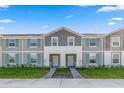 Two story townhome with gray siding, teal shutters, and a landscaped front yard at 710 Gardenia Ln, Davenport, FL 33897