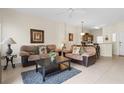 Open living room with two sofas, coffee table, and view to kitchen at 105 Pompano Beach Dr, Kissimmee, FL 34746