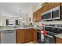 Kitchen with wood cabinets, stainless steel appliances, and granite countertops at 105 Pompano Beach Dr, Kissimmee, FL 34746