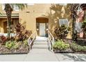 Front entrance of a tan townhouse with steps and landscaping at 105 Pompano Beach Dr, Kissimmee, FL 34746