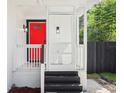 Bright red front door with black accents and a white porch at 1815 Larkin Ave, Orlando, FL 32812