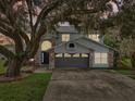 Two-story house with gray siding, dark gray garage door, and landscaping at 2291 E Riviera Blvd, Oviedo, FL 32765