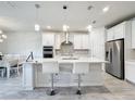 Modern kitchen with white cabinets, stainless steel appliances, and a large island at 5616 Arborvista Dr, St Cloud, FL 34771