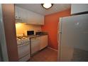 Small kitchen with white cabinets and appliances at 103 Oyster Bay Cir # 120, Altamonte Springs, FL 32701